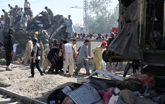 Security personnel and residents rescue injured blast victims from derailed carriages after an explosion targeted a train in Quetta on May 24, 2026.  (Photo by Banaras KHAN / AFP)
